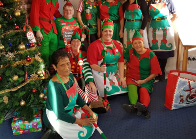The entire Loose Valley staff team in elf fancy dress by their Christmas Tree
