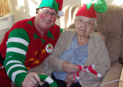 Loose Valley staff member with a resident and a cheeky Christmas elf