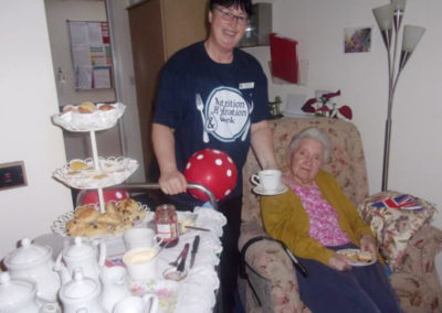 Loose Valley staff member Paula serving afternoon tea to a resident in her room