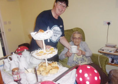 Loose Valley staff member serving afternoon tea to a resident in her room