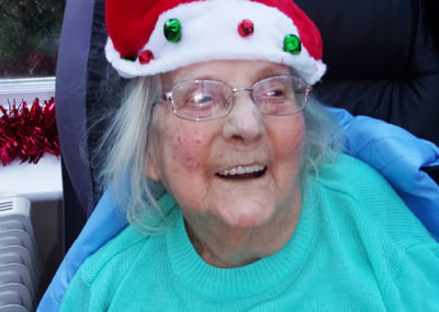 A resident smiling, wearing a Santa hat at the Loose Valley Christmas party
