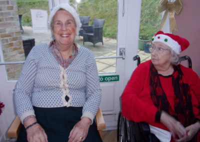 Two lady residents in Santa hats at the Loose Valley Christmas party