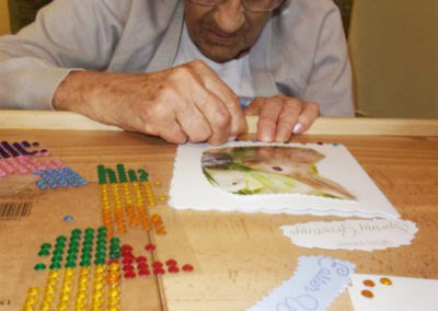 Lady resident concentrating on making an Easter card at Loose Valley Care Home