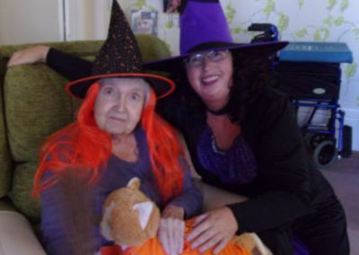 Loose Valley staff member with a resident wearing colourful witch costumes