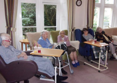Loose Valley Care Home residents seated in their lounge watching a singer