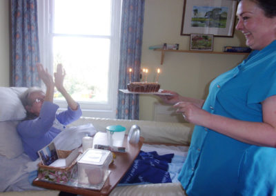 Loose Valley Care Home resident receiving a birthday cake, clapping