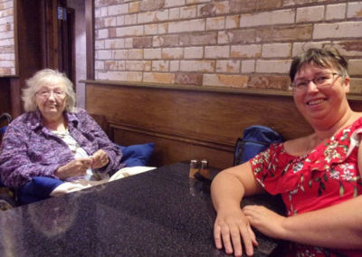 Resident and staff member in a cafe on an outing to Sheerness