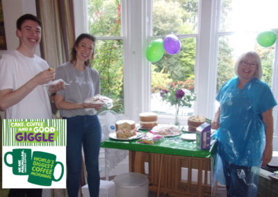 Staff at Loose Valley by a table of cakes at a Macmillan Coffee Morning