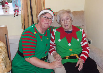 Staff member and lady resident dressed up as elves at Loose Valley