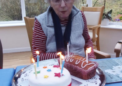 Lady resident with two birthday cakes