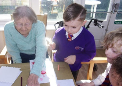Resident and children making Valentines cards together at Loose Valley