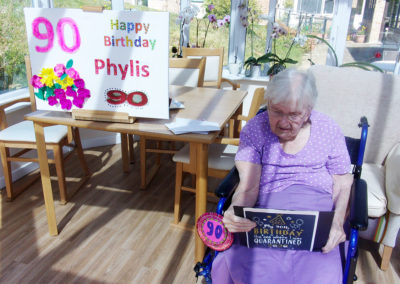 Resident on her birthday with cards and banners at Loose Valley Care Home