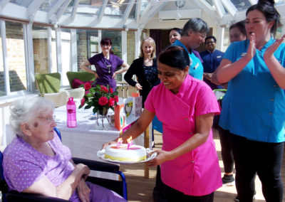 Resident on her birthday receiving her cake at Loose Valley Care Home