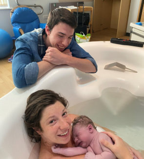 Couple with a birthing pool and their newborn baby