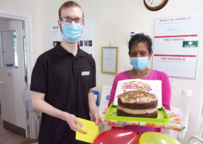 Manager and staff member recessing a birthday cake