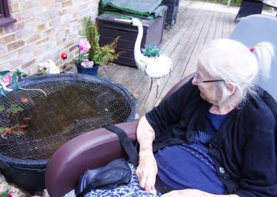 A resident watching the fish int he pond at Loose Valley Care Home
