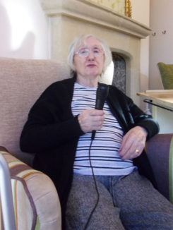 Resident with a microphone on Sing-a-long Sunday at Loose Valley Care Home