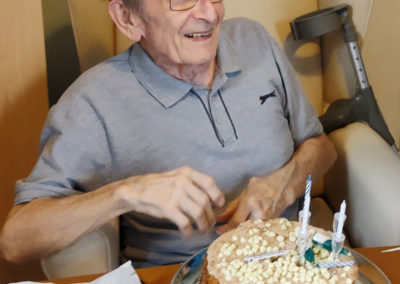 Loose Valley Care Home resident smiling at receiving his birthday cake