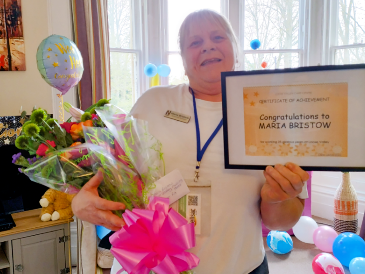 Maria with her certificate and flowers at Loose Valley Care Home 